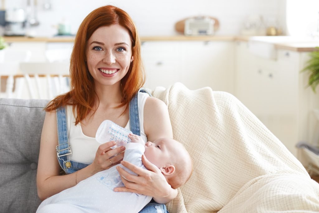 Vrouw voert baby na het reinigen van babyfles
